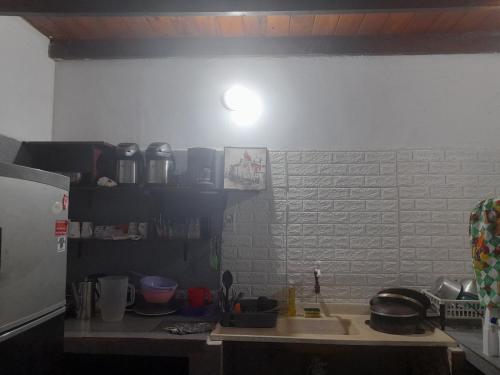 a kitchen with a sink and a white wall at La Nona in Puerto Iguazú