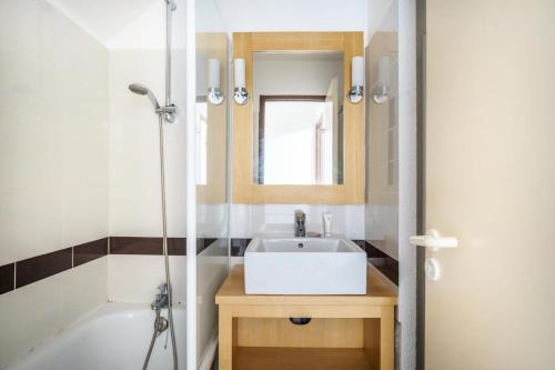 une salle de bain avec un lavabo blanc et une douche dans l'établissement Résidence Port du Crouesty - maeva Home - 2 Pièces 7 Personnes Confort MAE-5293, à Arzon