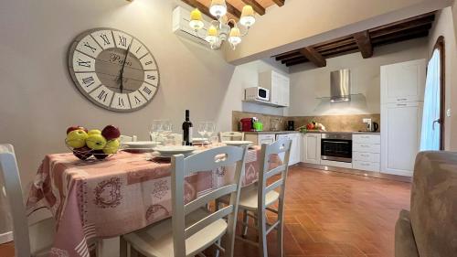 a dining room with a table and a clock on the wall at Borgo del Silenzio - Apartments with pool in Lajatico in Laiatico