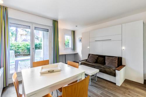 un salon avec une table et un canapé dans l'établissement Résidence Les Embruns - maeva Home - Studio 4 Personnes Selection MAE-5656, à Deauville