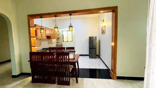 a dining room and kitchen with a table and chairs at Safi House in Boma la Ngombe