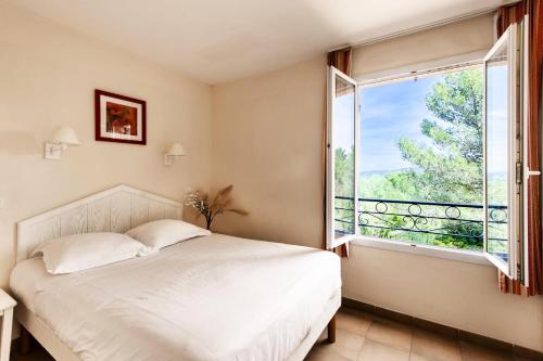 une chambre avec un lit et une grande fenêtre dans l'établissement Village Pont Royal en Provence - maeva Home - Appartement 2 pièces 7 personnes - Sélection MAE-6052, à Mallemort