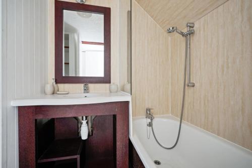 une salle de bain avec un lavabo, une baignoire et un miroir dans l'établissement Résidence Port du Crouesty - maeva Home - Appartement 2 pièces 7 personnes - Sélection MAE-7507, à Arzon