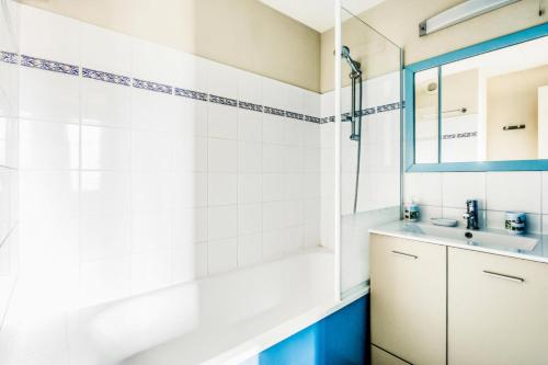 a bathroom with a tub and a sink and a mirror at Résidence Port Guillaume - maeva Home - Appartement 2 pièces 6 pers Sélection MAE-7351 in Dives-sur-Mer