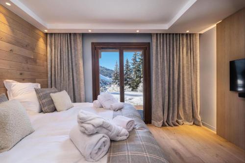 a bedroom with a large bed with towels on it at Résidence Rosoire - Chalets pour 12 Personnes 994 in Courchevel