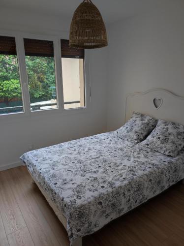 - un lit dans une chambre avec 2 fenêtres dans l'établissement Magnifique appartement centre ville, à Hyères