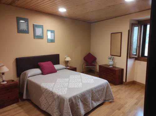 - une chambre avec un lit doté d'un oreiller rouge dans l'établissement Casa Rural La Maestra, 