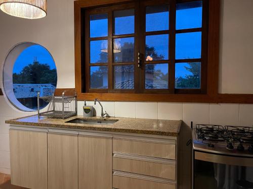 a kitchen with a sink and a window at Casas loft em Armação dos Búzios in Búzios