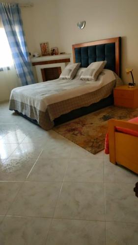 a bedroom with a bed with a rug on the floor at Logement calme très proche du centre in Oujda