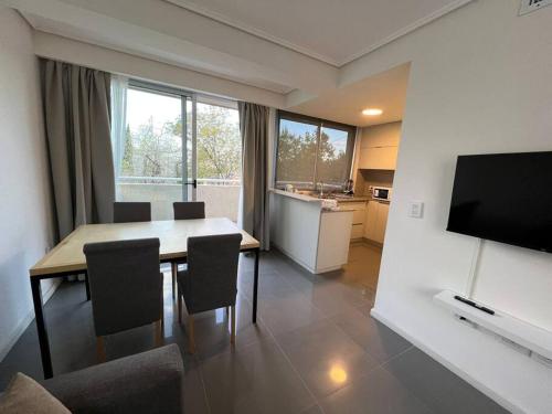 a kitchen and dining room with a table and a television at Departamento excelente ubicación Capital Mendoza in La Cieneguita
