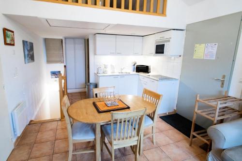 a kitchen and dining room with a table and chairs at Les Chalets Petit Bonheur - LES CHALETS PETIT BONHEUR - CHT93 MAE-2484 in Villarodin-Bourget