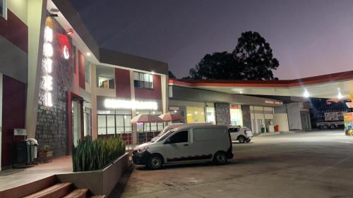 une petite voiture blanche garée devant un bâtiment dans l'établissement HOTEL EL CACIQUE POPAYAN, à Popayan