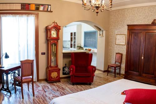 Rivarolo Mantovano的住宿－Convivium，一间卧室配有床、祖父钟和椅子