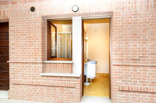 Rivarolo Mantovano的住宿－Convivium，砖墙,有门通往浴室