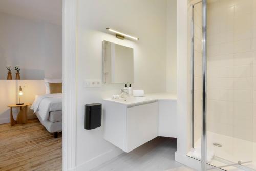 a white bathroom with a sink and a mirror at The 1894 Residence by Domani Hotels in Antwerp