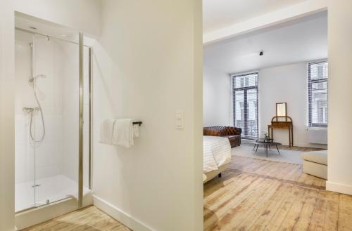 biała łazienka z prysznicem i łóżkiem w obiekcie The 1894 Residence by Domani Hotels w Antwerpii