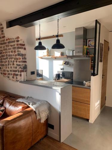 une cuisine avec deux lampes suspendues sur un plan de travail dans l'établissement L'appart sur le canal, à Paris