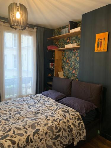 une chambre avec un lit et une fenêtre dans l'établissement L'appart sur le canal, à Paris