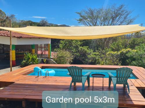 2 sillas y una mesa junto a la piscina en La Casa del Conde, en Naranjo