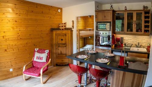 a kitchen with a counter and a table and chairs at Résidence Les Ecrins - Studio pour 4 Personnes 224 in Les Orres