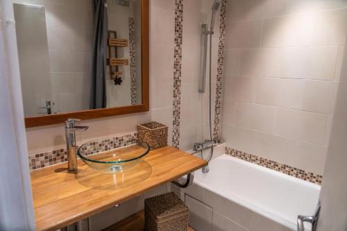La salle de bains est pourvue d'un lavabo en verre et d'une baignoire. dans l'établissement Résidence Les Ecrins - Adorable studio au coeur de la forêt des Orres MAE-6224, aux Orres