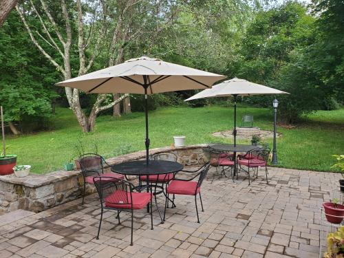 a patio with tables and chairs with umbrellas at Mountain Home Bed & Breakfast in Front Royal