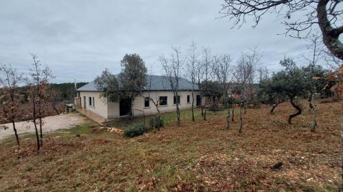 una casa in mezzo a un campo con alberi di La Lumbre: encanto con piscina todo el año a Castillejo de Mesleón