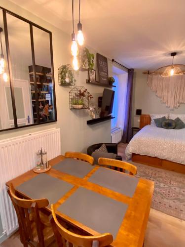 un salon avec une table et un lit dans l'établissement Les Logis Aux portes de la Vallée de Chevreuse, à Gometz-le-Châtel