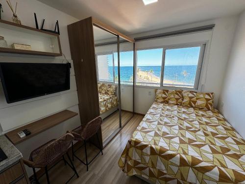 - une chambre avec un lit et une grande fenêtre dans l'établissement Studio Aconchegante com vista mar no Smart Pituba, à Salvador