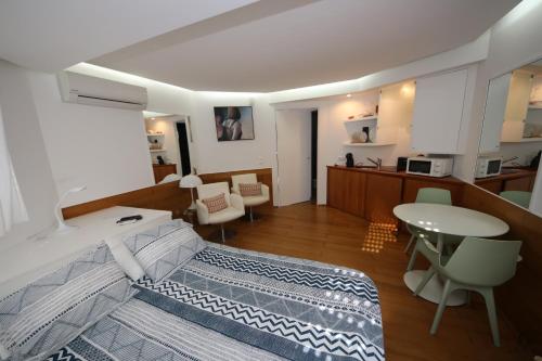 a bedroom with a bed and a table and chairs at Cosy Studio Azores Beach in Ponta Delgada