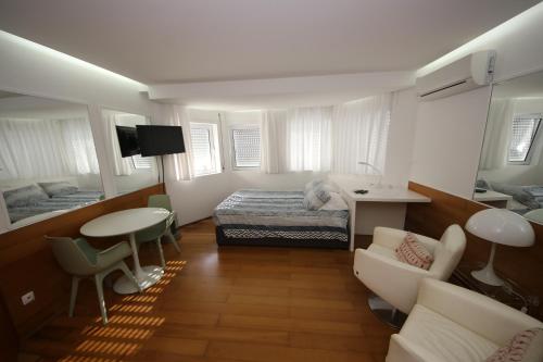 a bedroom with a bed and a table and chairs at Cosy Studio Azores Beach in Ponta Delgada