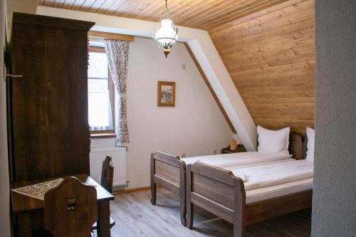 Schlafzimmer mit einem Bett, einem Tisch und einem Fenster in der Unterkunft Pensiunea Agroturistică Erdélykincse Panzió in Sicasău