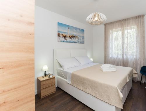 una camera bianca con un letto e una finestra di Villa Residence Sunrise a Privlaka (Brevilacqua)