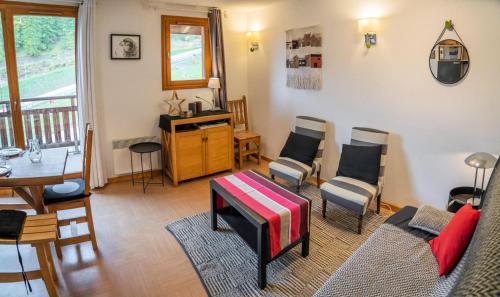un salon avec un canapé, des chaises et une table dans l'établissement Résidence Le Parc Des Airelles - Charmant duplex avec vue imprenable sur les pistes MAE-8284, aux Orres