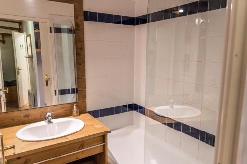 a bathroom with two sinks and a mirror at Résidence Le Parc Des Airelles - Pièces 284 in Les Orres