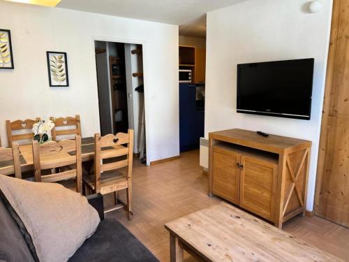 - un salon avec une télévision et une table à manger dans l'établissement Résidence Le Parc Des Airelles - Escapade pour 6 personnes au pied des pistes MAE-9474, aux Orres
