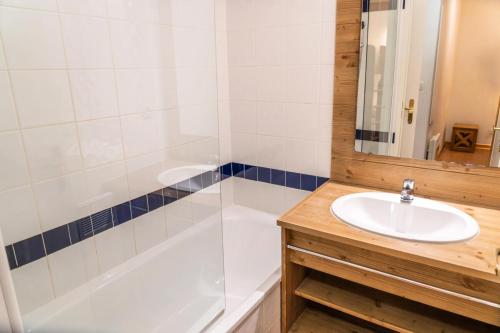 W łazience znajduje się umywalka, wanna i prysznic. w obiekcie Résidence Le Parc Des Airelles - 2 Pièces pour 6 Personnes 474 w mieście Les Orres