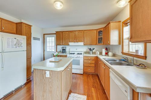 a kitchen with wooden cabinets and a white refrigerator at McDowell Highland County River Retreat with Views! in Williamsville