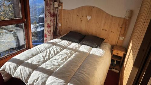 un lit dans une chambre avec une grande fenêtre dans l'établissement Résidence Archeboc - Appartement 4 personnes à Arc 1800 proche des pistes dans le village de Charmettoger MAE-2194, à Arc 1800