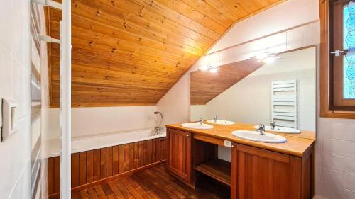 La salle de bains est pourvue de 2 lavabos et d'un plafond en bois. dans l'établissement Résidence Hameau - Chalet spacieux · Sauna · Cheminée MAE-7349, à Flaine
