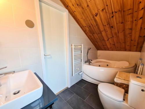 une salle de bain avec un lavabo, des toilettes et une baignoire dans l'établissement Résidence Hameau - Chalet lumineux · Poêle à bois · WIFI gratuit et illimité · Garage MAE-7353, à Flaine