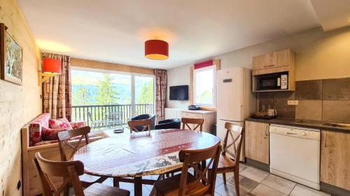 une cuisine et une salle à manger avec une table et des chaises dans l'établissement Résidence Les Pleiades - Appartement spacieux et lumineux · Centre station · Balcon · Parking couvert MAE-7355, à Flaine