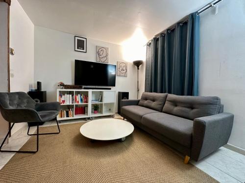 - un salon avec un canapé et une table dans l'établissement Aubervilliers maison de ville près métro 7 by immo kit bnb, à Aubervilliers