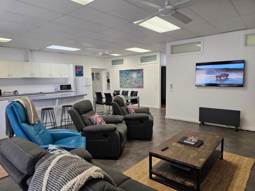 a living room with couches and a flat screen tv at Aart Apartments in Port Lincoln