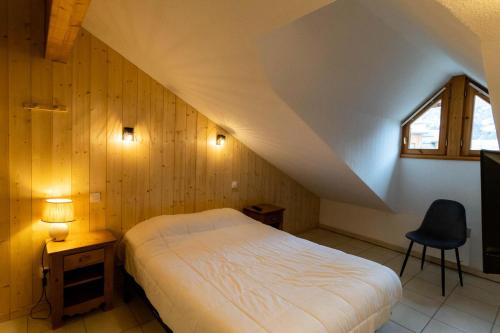 une chambre avec un lit, une fenêtre et une chaise dans l'établissement Résidence Le Balcon Des Airelles - Joli appartement redécoré en face des pistes MAE-0774, aux Orres