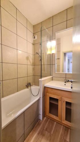 une salle de bain avec une baignoire et un lavabo et une baignoire dans l'établissement Residence De La Foret - Appartement confortable · Proche des pistes · Casier à ski MAE-7372, à Flaine