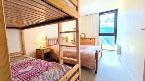 a bedroom with two bunk beds and a window at Résidence Belier - 2 Pièces pour 6 Personnes 84 in Flaine