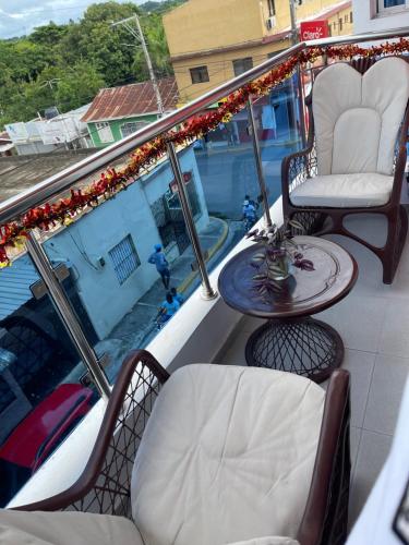 a balcony with two chairs and a table on a roof at Plataview Apartahotel apt 3A in Monte Plata