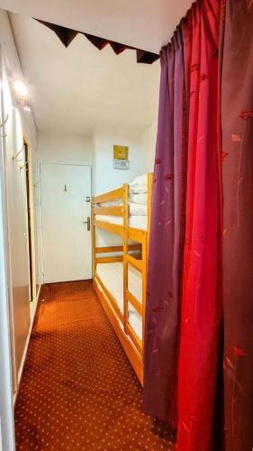 Cette chambre comprend 2 lits superposés et un rideau. dans l'établissement Résidence Andromede - Studio pour 4 Personnes 12, à Flaine