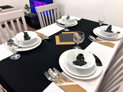 a dining table with white plates and silverware on it at Entire House, Sleeps 5, FreeParking, Work&Leisure in Shenley Brook End